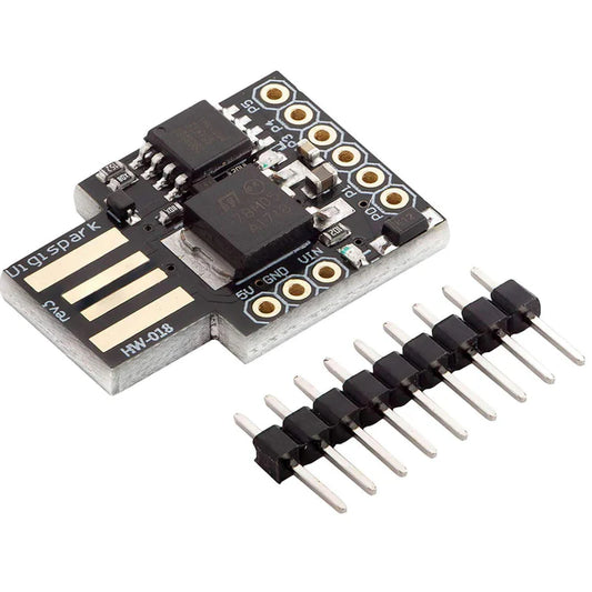 A Digispark ATTINY85 USB Development Board featuring a black microcontroller board with a set of pins and a USB connector.
